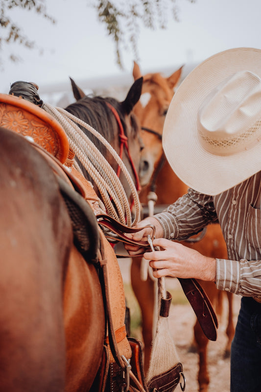 a man in a cowboy hat is petting a horse