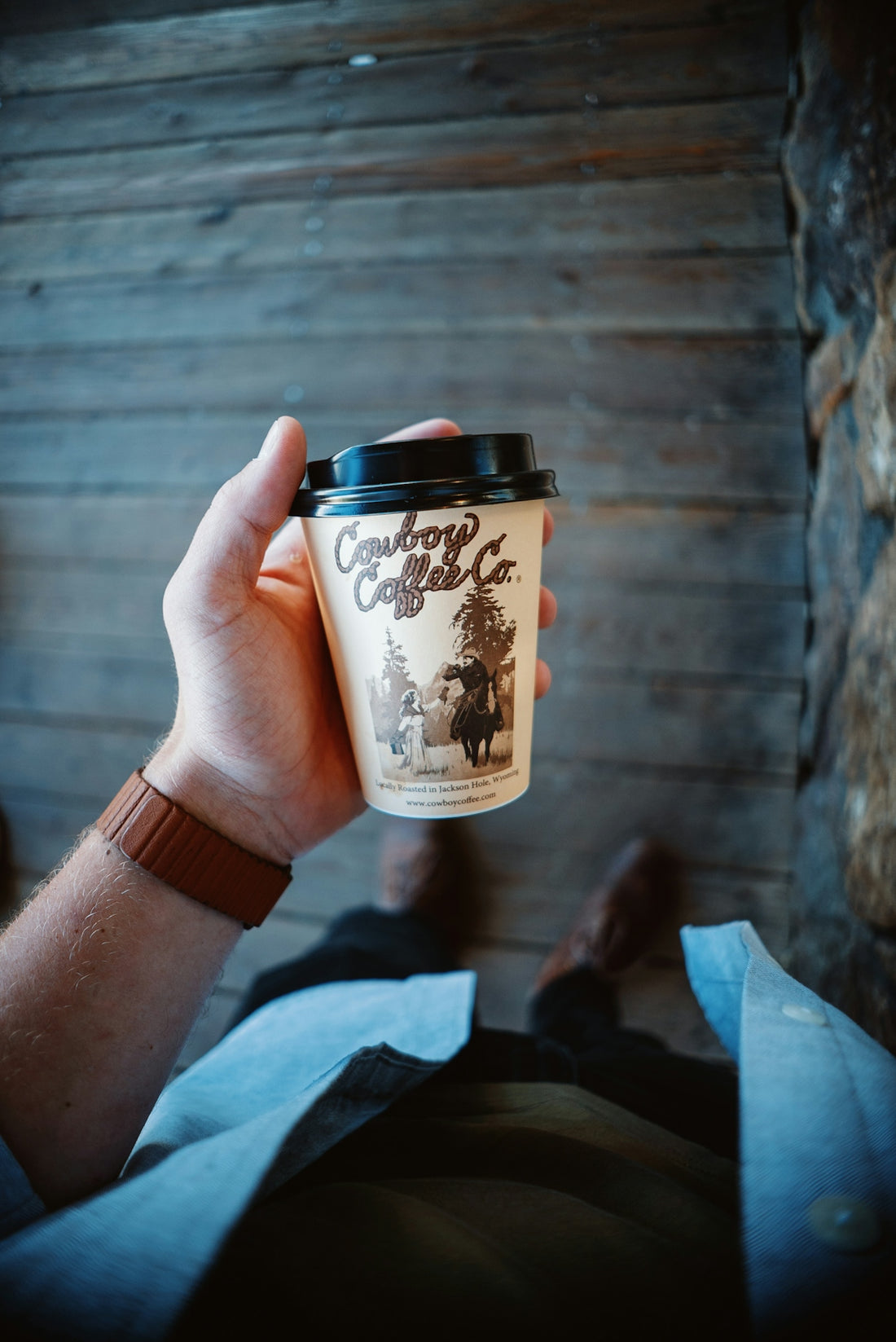 a person holding a cup of coffee in their hand