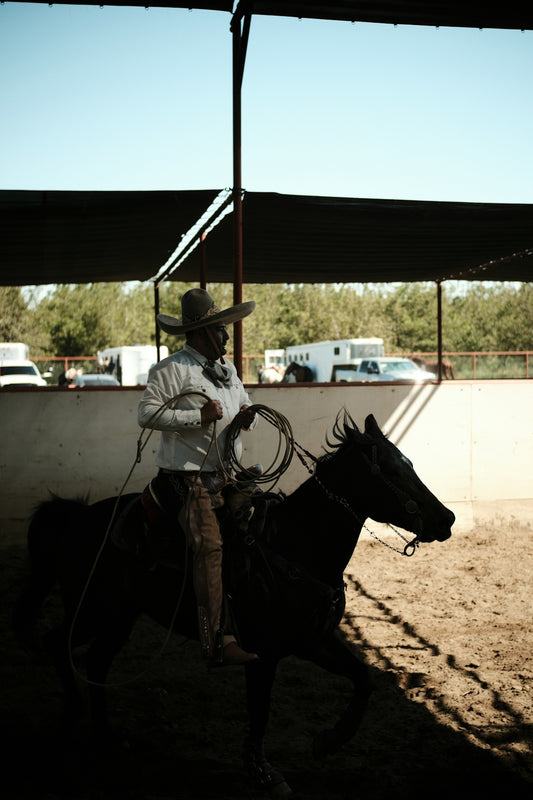 a man in a cowboy hat riding a horse
