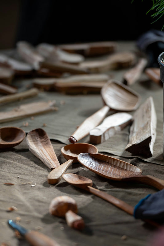 Hand carved wooden spoons and wood pieces on table